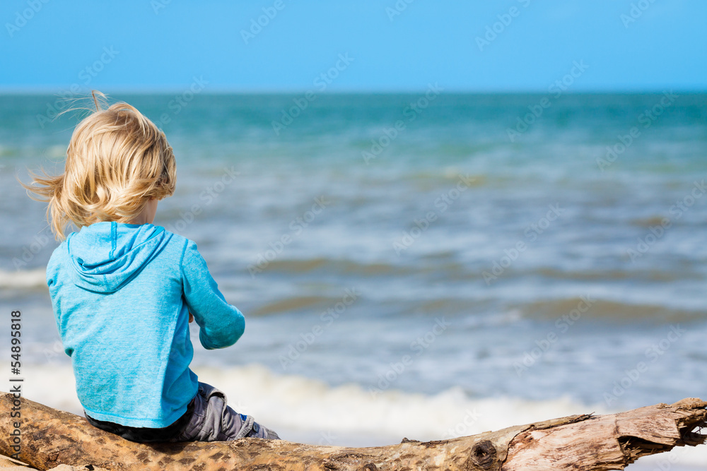 Young child sitting at the beach