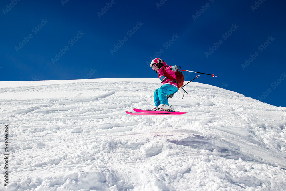 Little girl skier flies over the slope