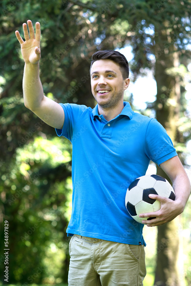 Man with soccer ball. Cheerful young man holding a soccer ball a