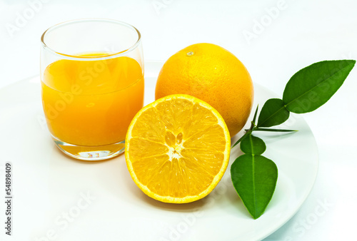 Glass of fresh orange juice with sliced orange .