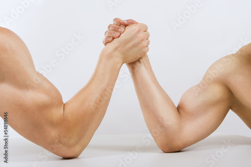 Two muscular hands clasped arm wrestling