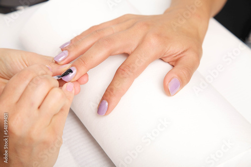 Manicure - Beautiful manicured woman s nails with violet nail po