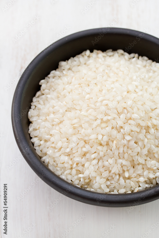 dry rice in black bowl on white table dry rice in black bowl on white table
