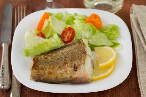 fried fish with salad and lemon