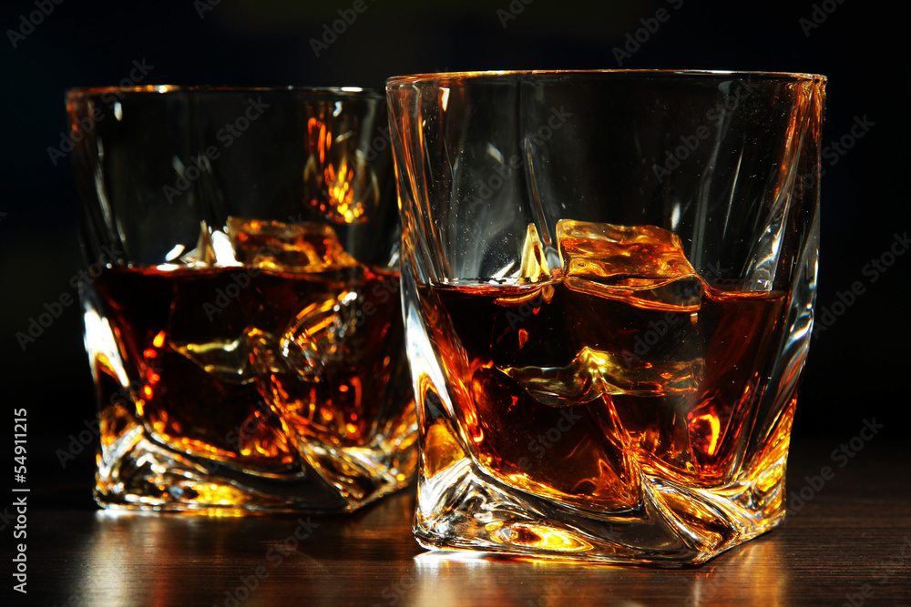 Glasses of whiskey, on dark background