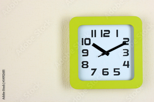 Office clock on color wall background