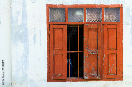 Red wooden window with white wall