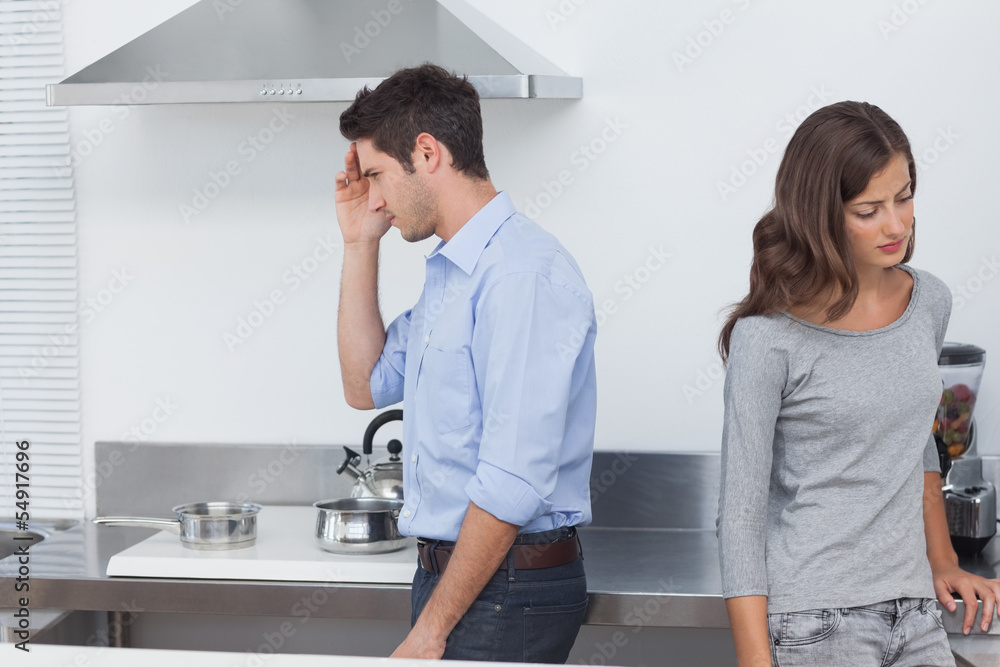 Couple sulking at each other in the kitchen Couple sulking at each other in the kitchen