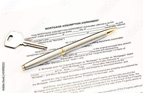 Mortgage assumption agreement with a pen for signature and a key