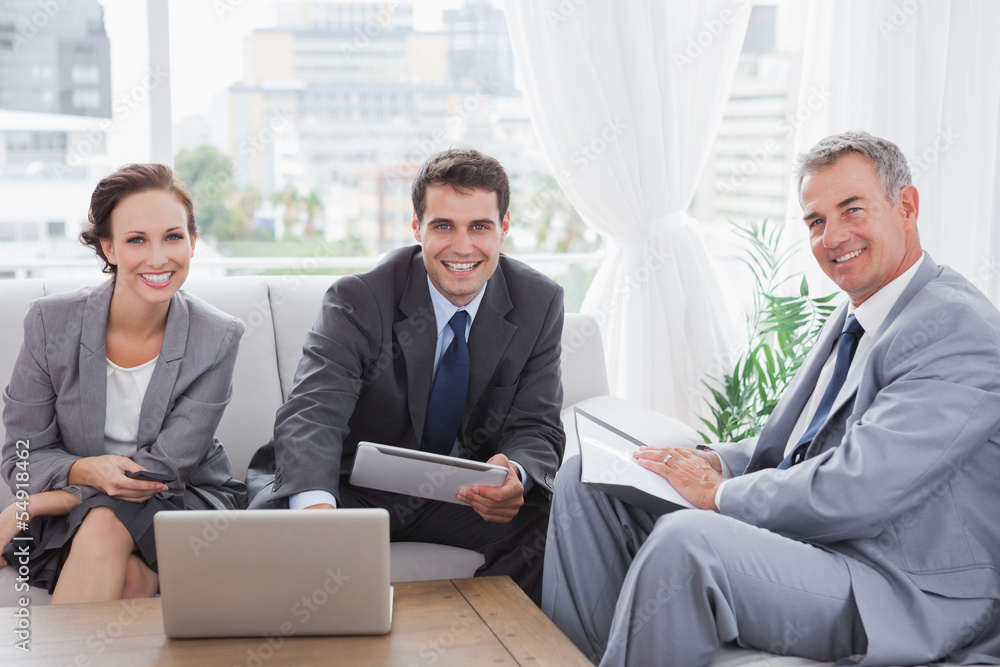 Business people smiling at camera while having a meeting Business people smiling at camera while having a meeting