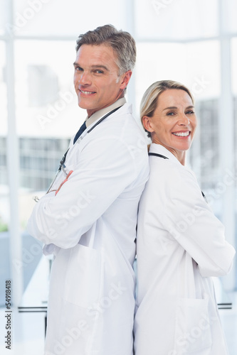 Experienced doctors posing together back to back
