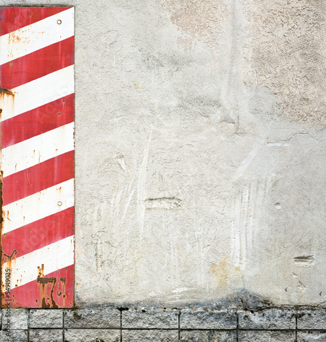 concrete wall with red and white warning stripes