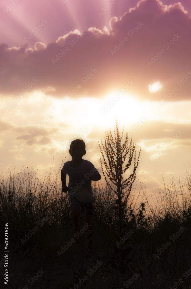 Silhouette of a child running at the sunset - 2