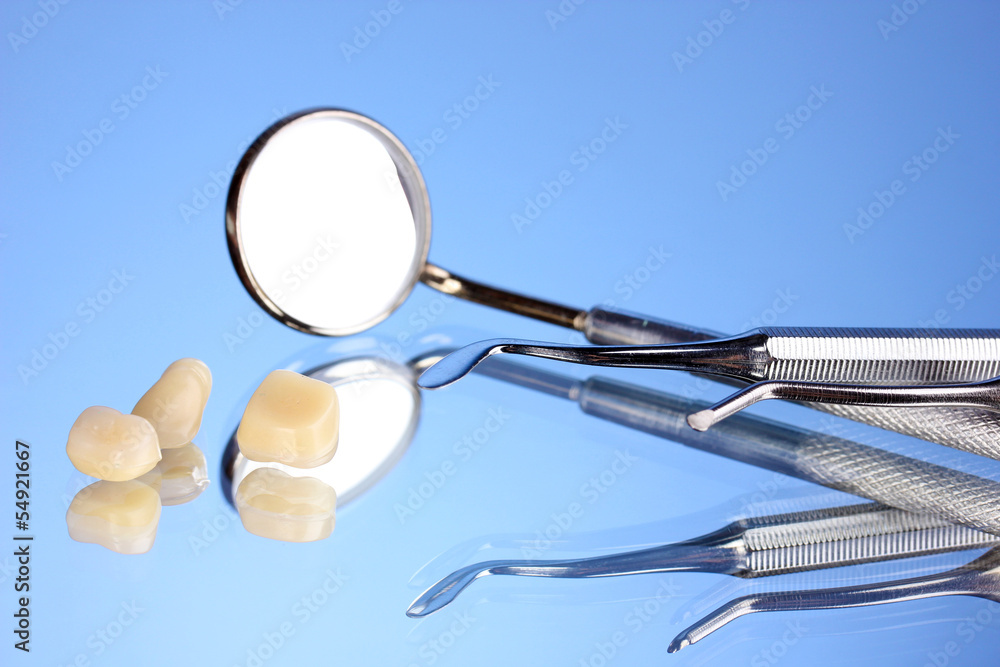dental mirror with denture teeth on blue background dental mirror with denture teeth on blue background