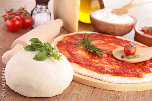 pizza dough with tomato sauce and ingredients