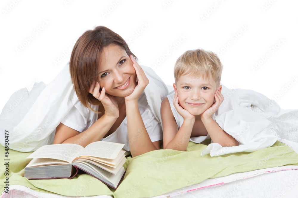 Happy family - mother and son lying on the white bed Happy family - mother and son lying on the white bed
