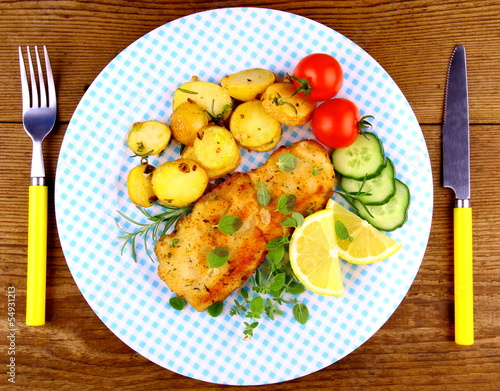Fried fish fillet with rosemary potatoes and vegetables