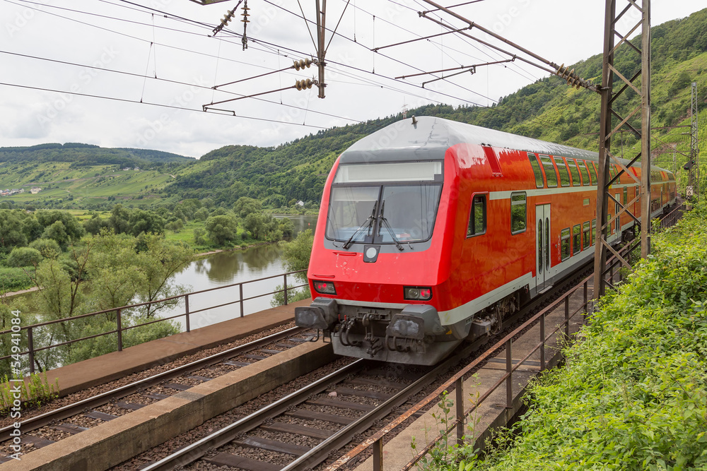 Train driving along river Moselle in Germany