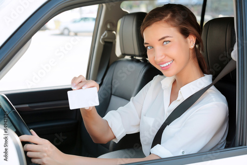 girl in a car showing an empty white card for your message © Nobilior