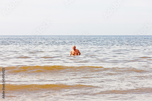 Single retired senior man enjoying the refreshment of the sea on