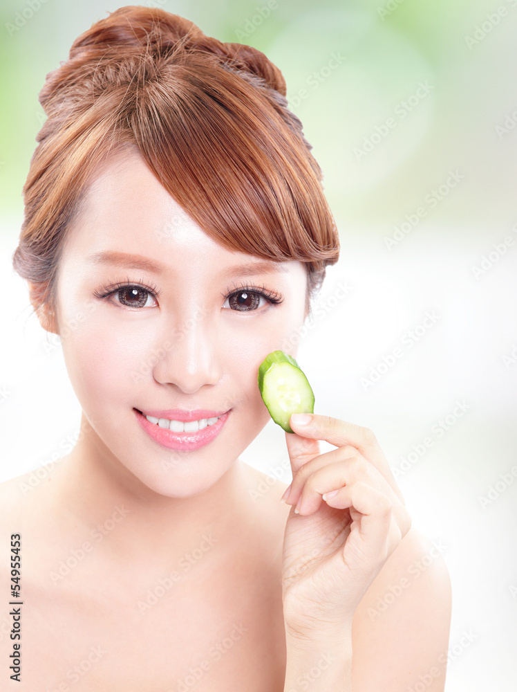 beautiful woman holding cucumber slices on face beautiful woman holding cucumber slices on face