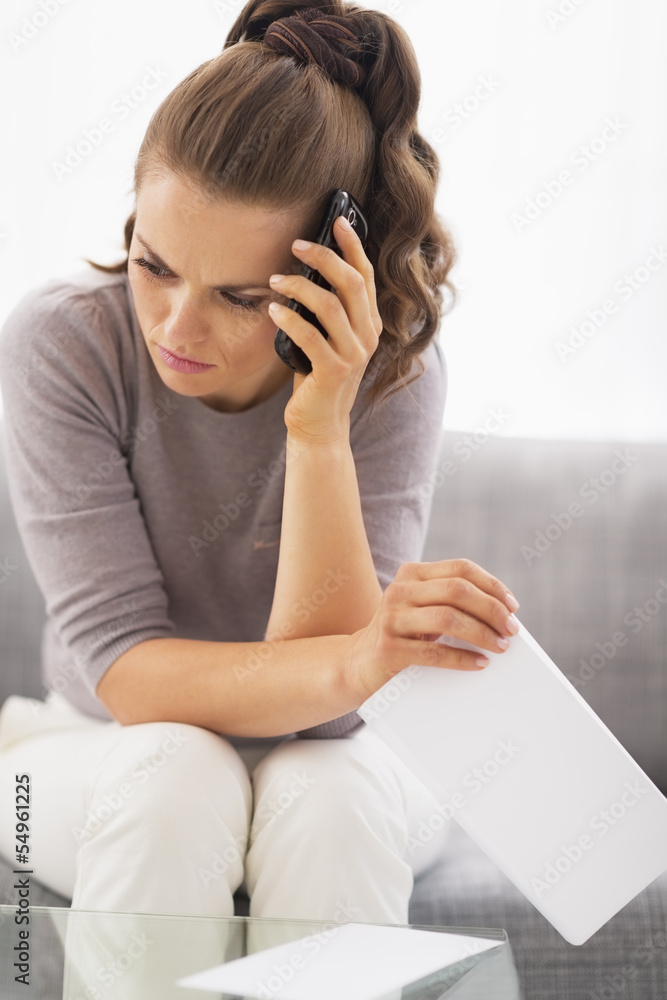 Frustrated young woman with letter and cell phone Frustrated young woman with letter and cell phone