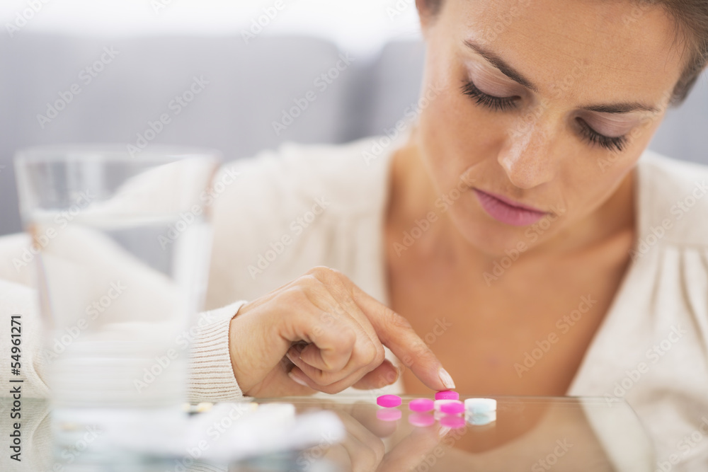 Fototapeta premium Closeup on frustrated young woman playing with pills