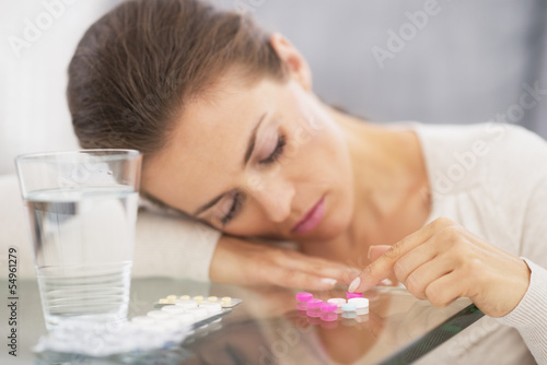 Cuadro en lienzo Closeup on stressed young woman playing with pills