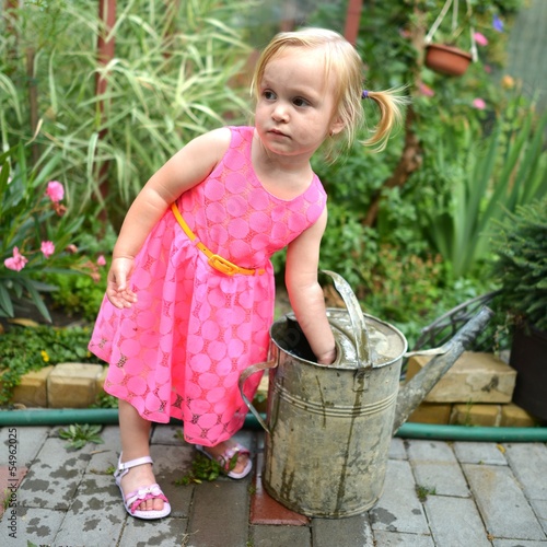 Caucasian baby lifting watering can photo