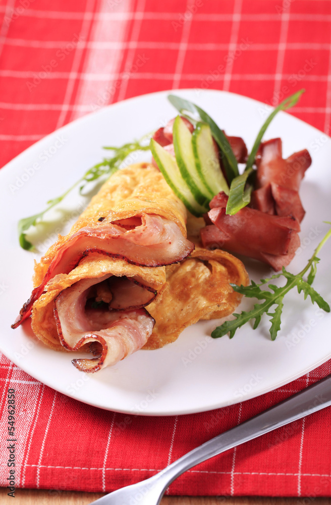 Egg omelet with bacon and sausages
