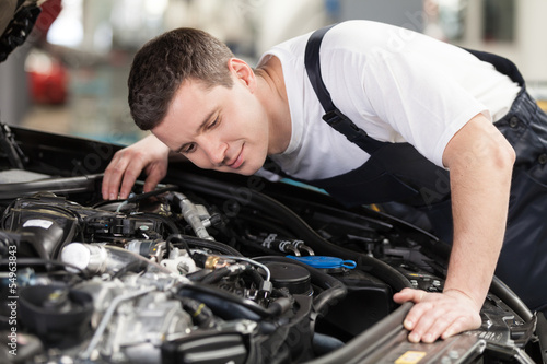 Confident auto mechanic. Confident mechanic listening to the car © BlueSkyImages