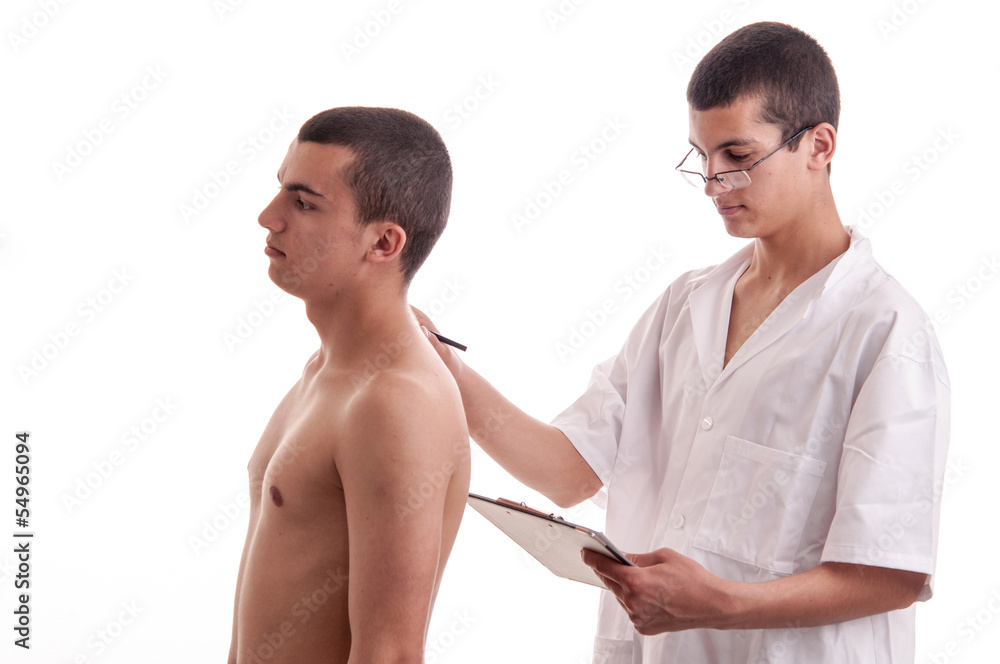 Teenager is examined by a young doctor, who notes the patient sy Teenager is examined by a young doctor, who notes the patient sy