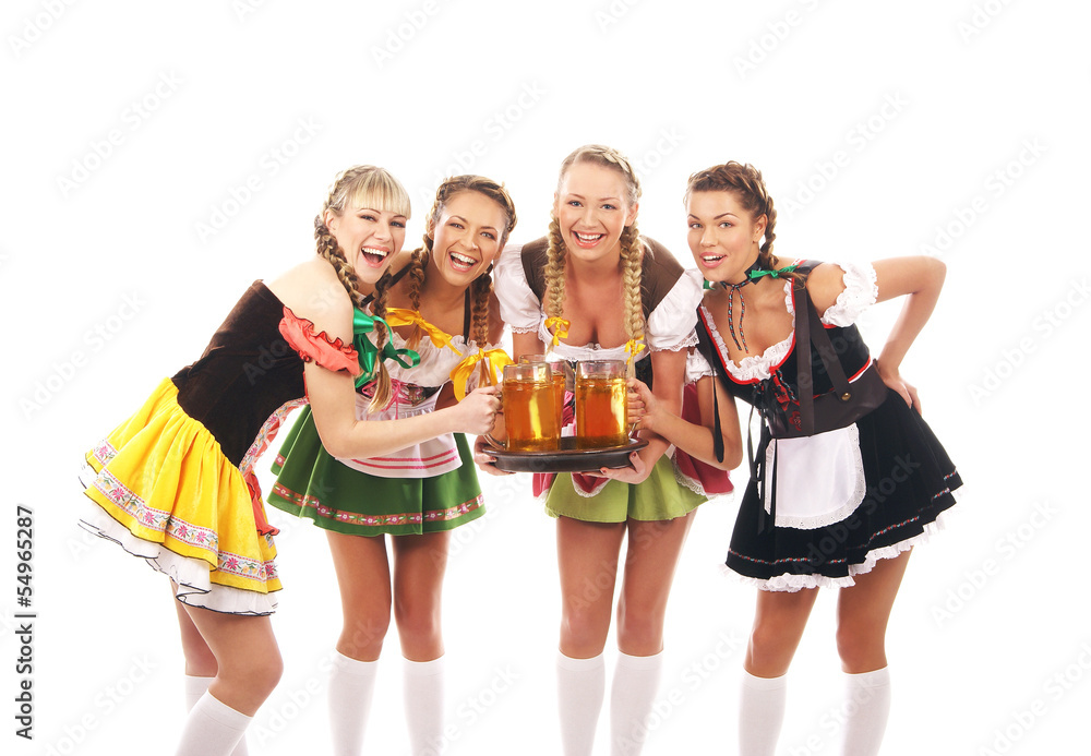 Fototapeta premium Four young women in Bavarian clothes holding glasses of beer