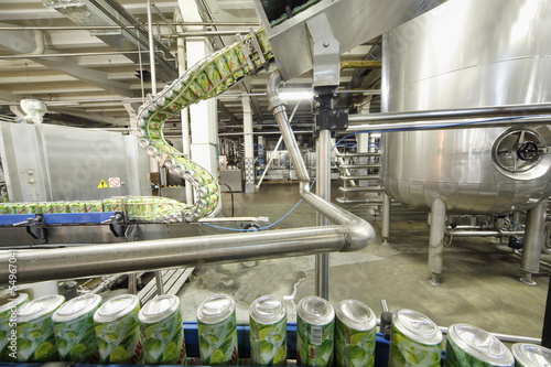 Green cans go on conveyor in factory