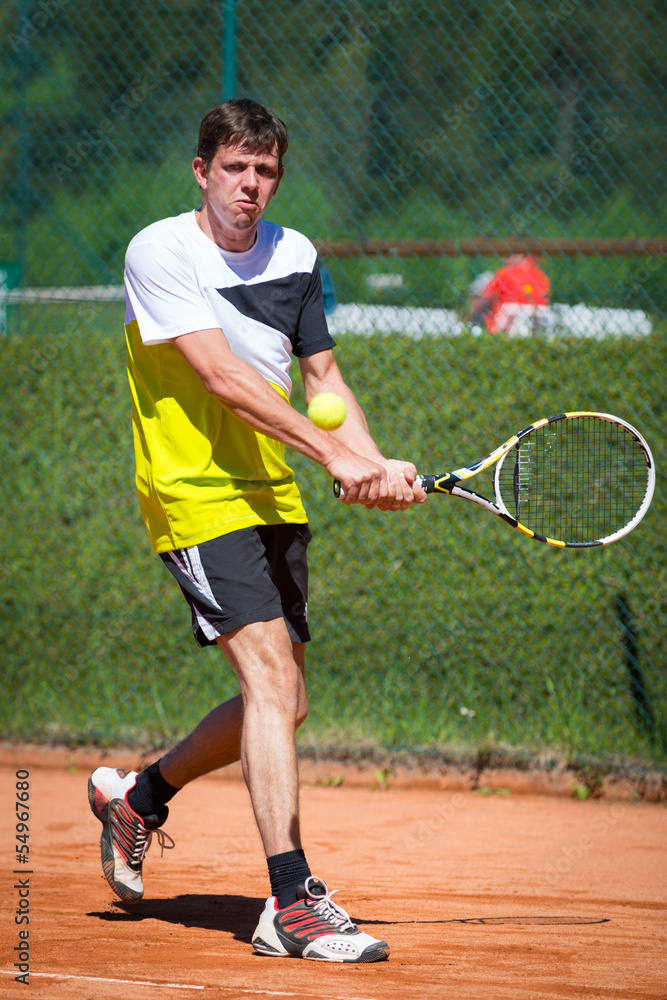 two handed backhand of tennis player on sand court