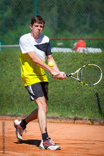 two handed backhand of tennis player on sand court © A2LE