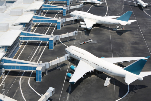 Canvas Print Models of modern white aircraft standing at miniature airport.