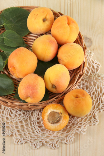 Apricots on wicker coasters on napkin on  wooden table