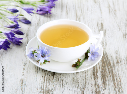 Cup of tea with chicory, on wooden background