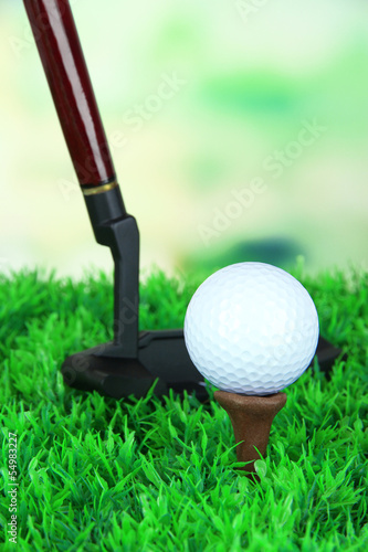 Golf ball and driver on green grass outdoor close up