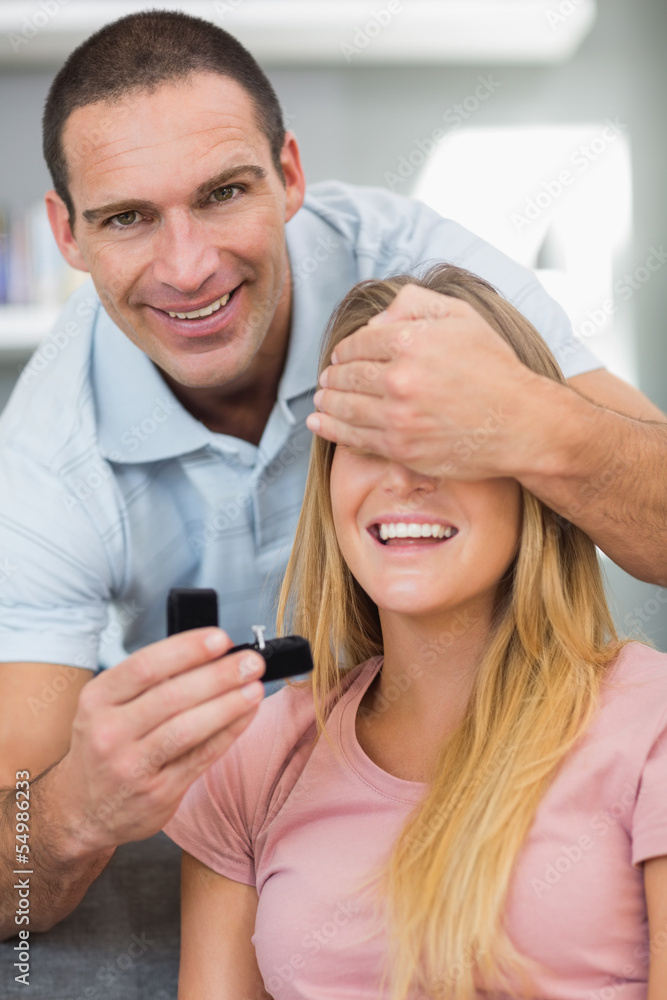 Happy man about to propose to his unsuspecting girlfriend on the Happy man about to propose to his unsuspecting girlfriend on the