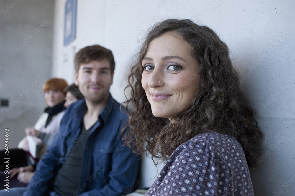 Germany, Leipzig, Man and women smiling, students in background Germany, Leipzig, Man and women smiling, students in background