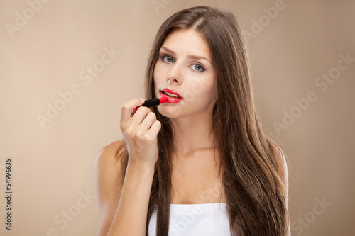 Young woman applying lipstick