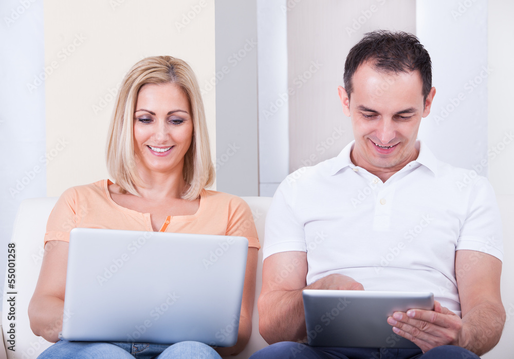 Mid-adult Couple Using Laptop And Digital Tablet Mid-adult Couple Using Laptop And Digital Tablet