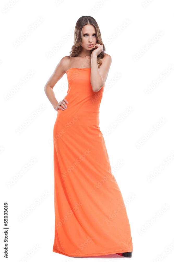 Beauty in dress. Beautiful young woman in orange dress posing wh
