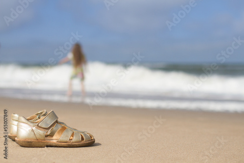 Girls sandals on sand at beach
