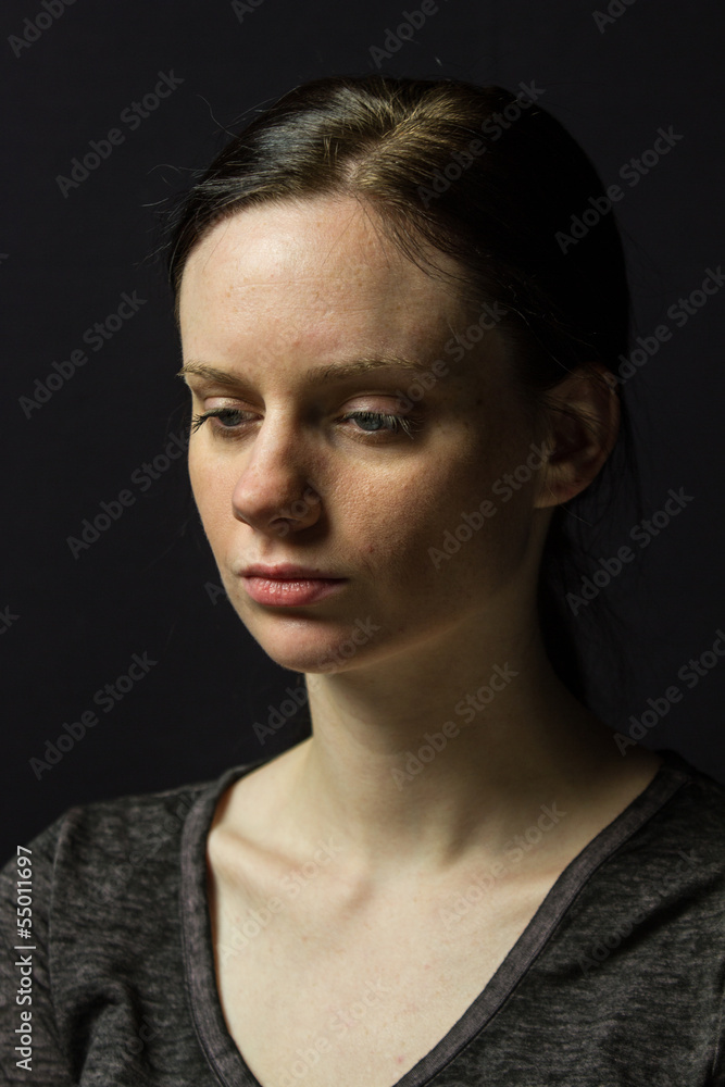 Young woman posing against black background, vertical Young woman posing against black background, vertical
