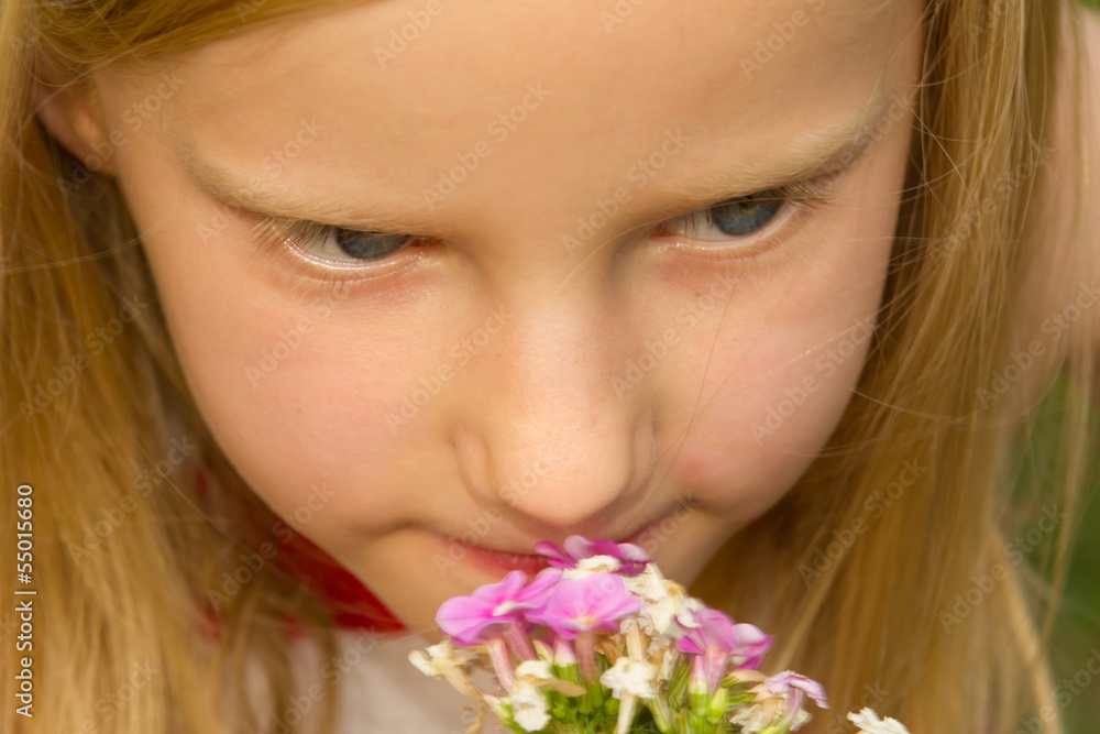Adorable young schoolgirl smelling pink flower on a sunny day cl Adorable young schoolgirl smelling pink flower on a sunny day cl