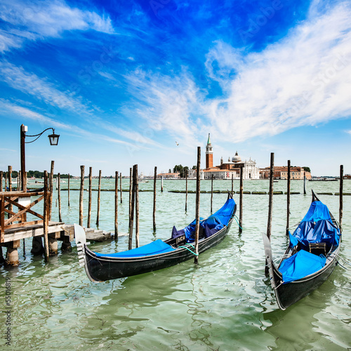 Venice, gondolas or gondole and church on background. Italy