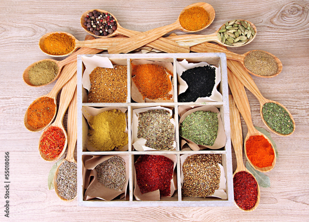 Assortment of spices in wooden spoons and box,